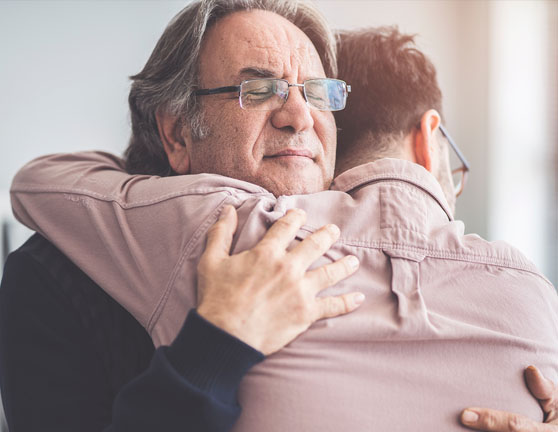 Dos hombres abrazándose con los ojos cerrados