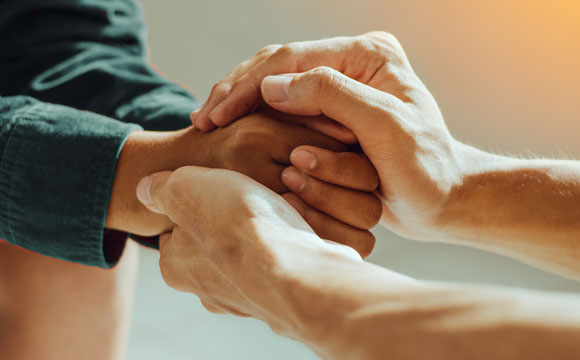 una persona cogiendo las manos a otra