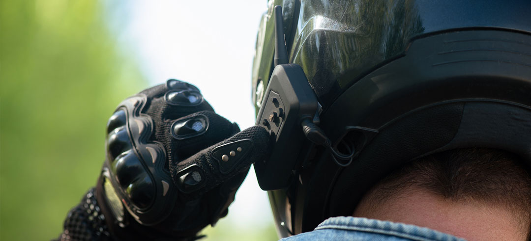 Motociclista encendiendo auriculares mientras se prepara para conducir