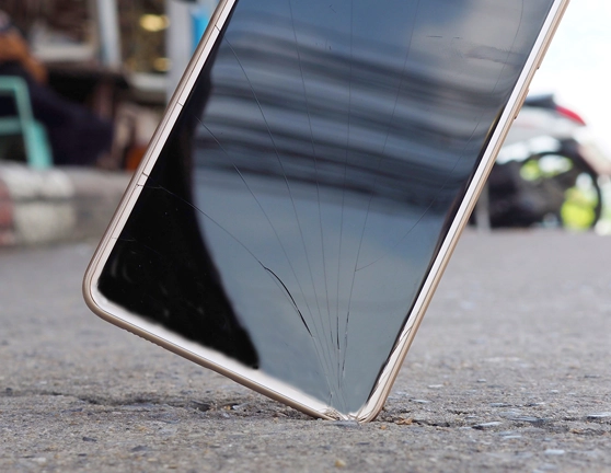 Smartphone cayendo al suelo y mostrando la pantalla rota